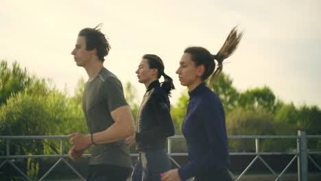 Los-Corredores-Por-La-Mañana,-Dos-Mujeres-Jóvenes-Y-Un-Hombre-Corren-Juntos-Con-Un-Estilo-De-Vida-Saludable.